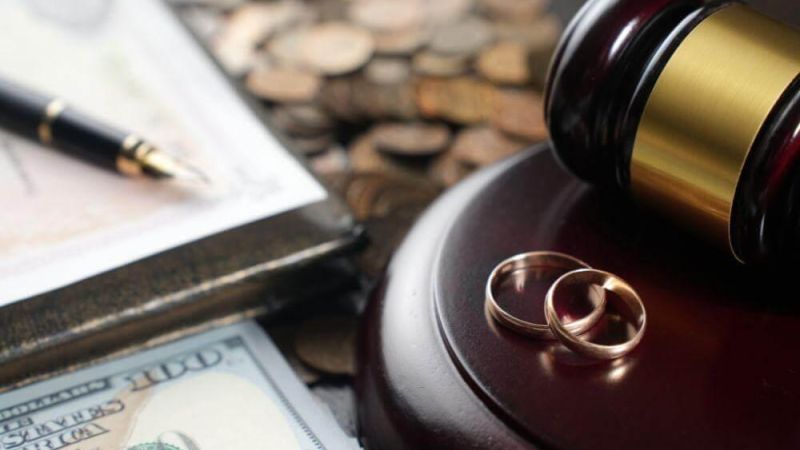 a judge's gavel with two wedding rings on top of it
