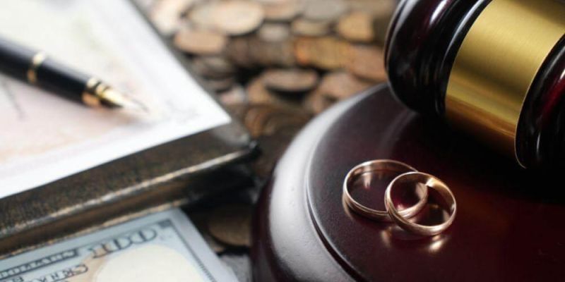 a judge's gavel with two wedding rings on top of it