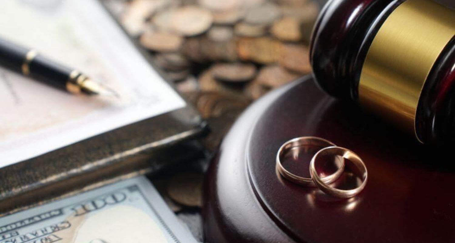 a judge's gavel with two wedding rings on top of it