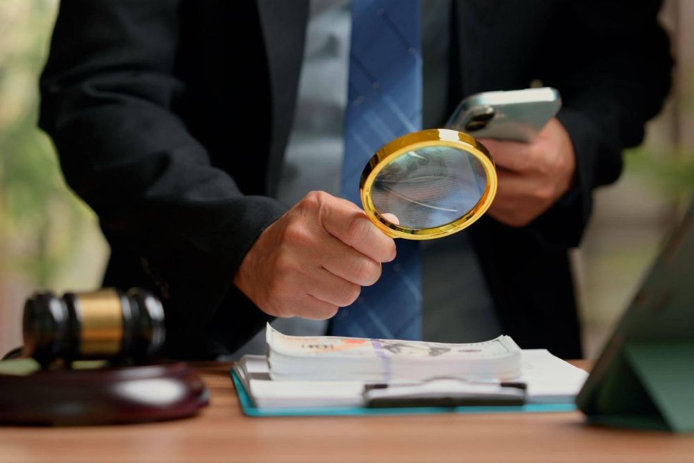 Forensic accountant with magnifying glass for