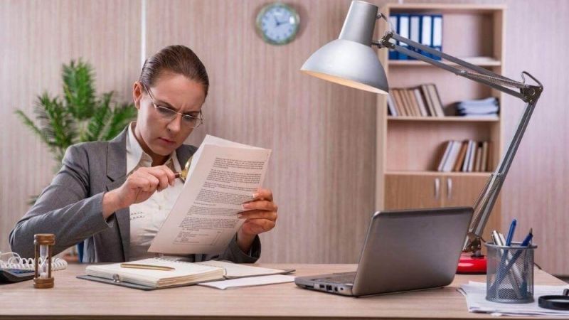Woman reviewing documents, possibly related to