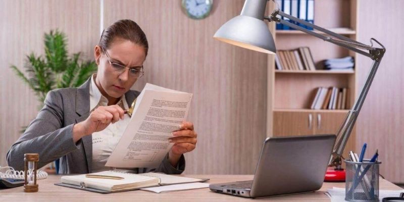 Woman reviewing documents, possibly related to