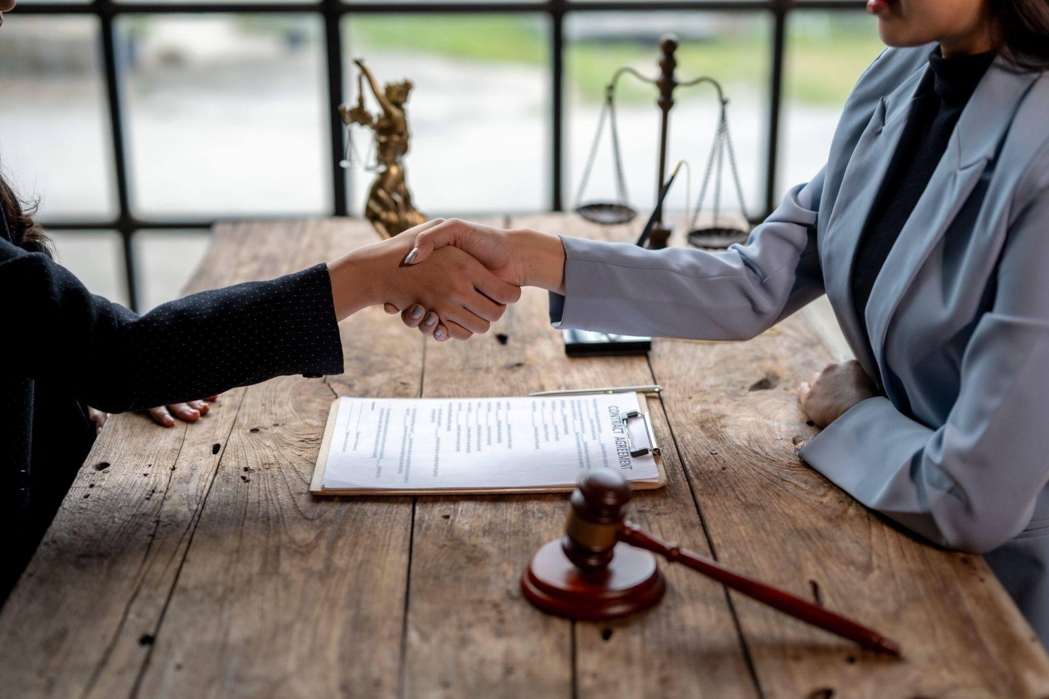 a couple of people shaking hands over a piece of paper